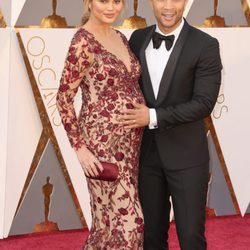 John Legend tocando la barriguita de Chrissy Teigen en la alfombra roja de los Premios Oscar 2016