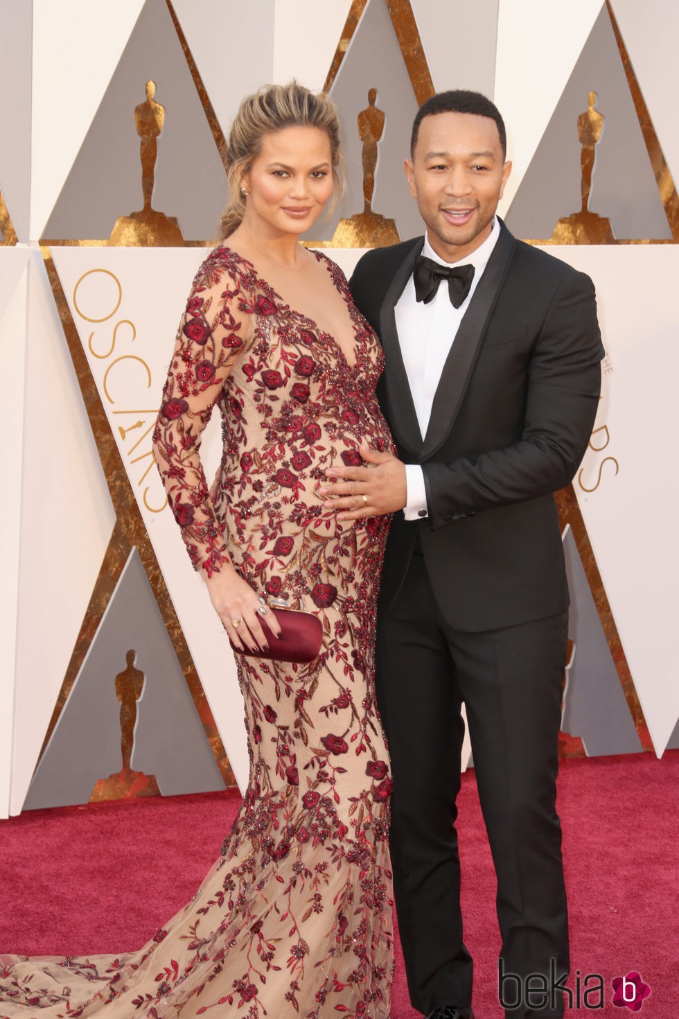 John Legend tocando la barriguita de Chrissy Teigen en la alfombra roja de los Premios Oscar 2016