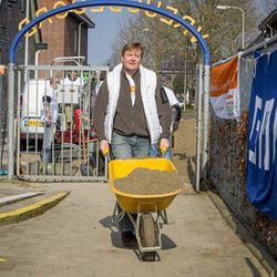 El Rey Guillermo Alejandro de Holanda cargando una carretilla con arena