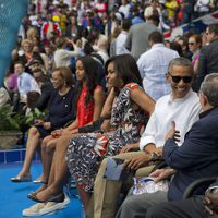 Barack Obama junto a su familia y Raul Castro en un partido de baseball en Cuba