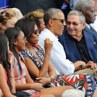 Barack Obama hablando con Raul Castro en un partido de baseball en Cuba