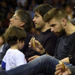 Gerard Piqué da la merienda a su hijo Milan en un partido de baloncesto