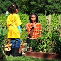 Michelle Obama junto a dos niños en la recogida de la cosecha en la Casa Blanca