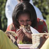 Michelle Obama come con satisfacción tras recoger la cosecha en la Casa Blanca