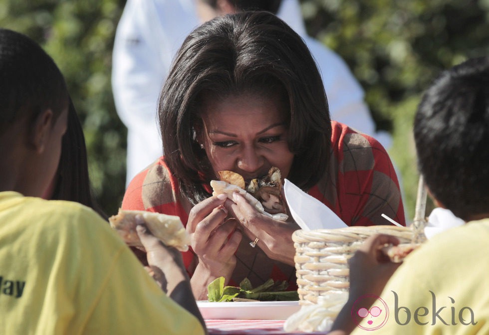 Michelle Obama come con satisfacción tras recoger la cosecha en la Casa Blanca