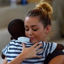 Miley Cyrus abraza a un niño durante su visita a Haití