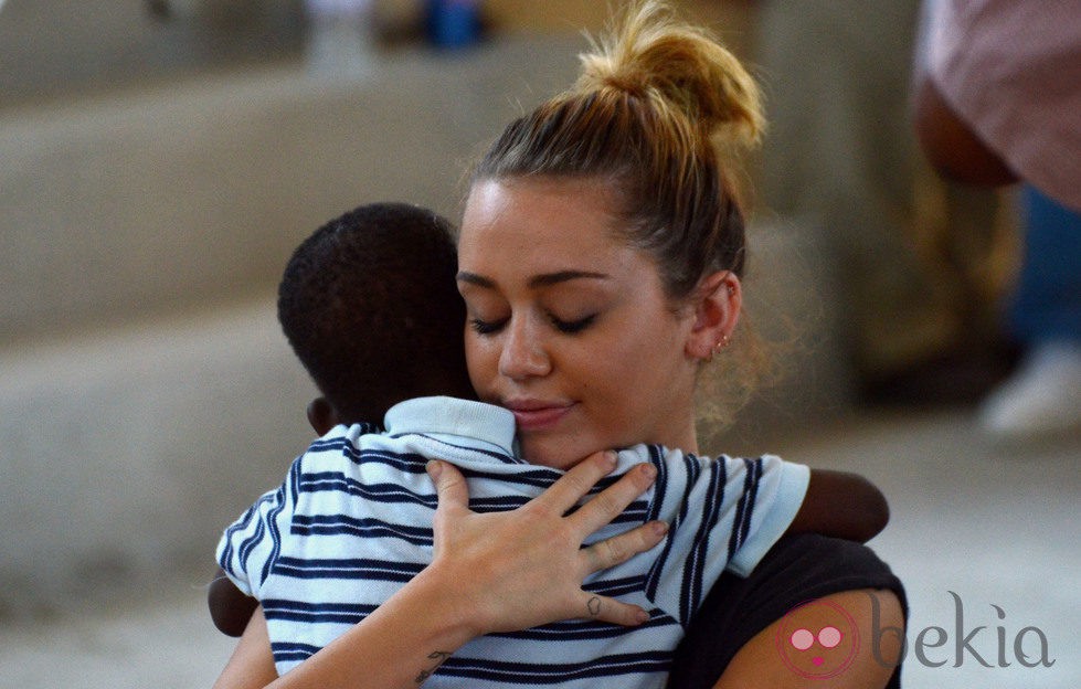 Miley Cyrus abraza a un niño durante su visita a Haití