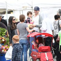 Mila Kunis, Ashton Kutcher y su hija Wyatt charlando con unos conocidos