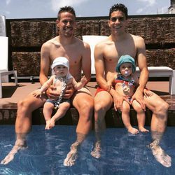 Manu Hervás con su hijo Lars y Marc Bartra con su hija Gala en la piscina