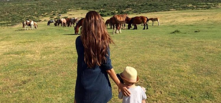 Sara Carbonero con su hijo Martín viendo unos caballos en Navalacruz