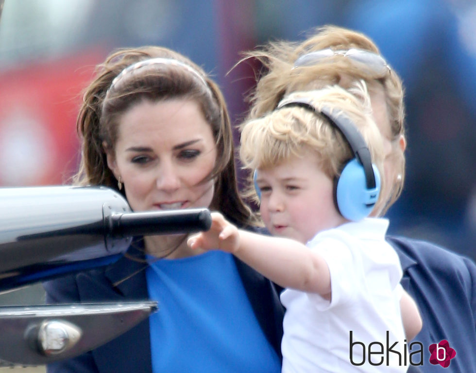 Jorge de Cambridge tocando un helicóptero en brazos de su madre Kate Middleton