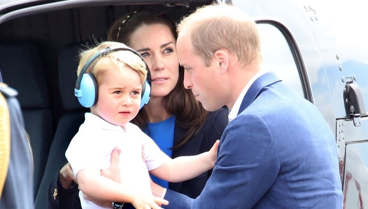 Los Duques de Cambridge y su hijo Jorge de Cambridge bajando de un helicóptero