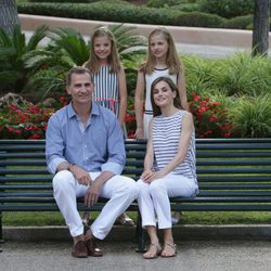 Los Reyes Felipe VI y Letizia con sus hijas en un banco de los jardines de Marivent