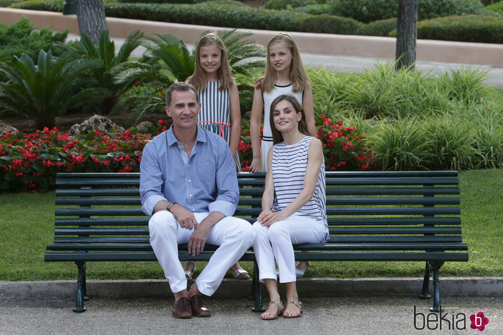 Los Reyes Felipe VI y Letizia con sus hijas en un banco de los jardines de Marivent