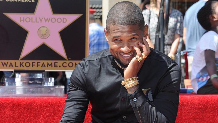 Usher, muy sonriente con su estrella en el Paseo de la Fama de Hollywood