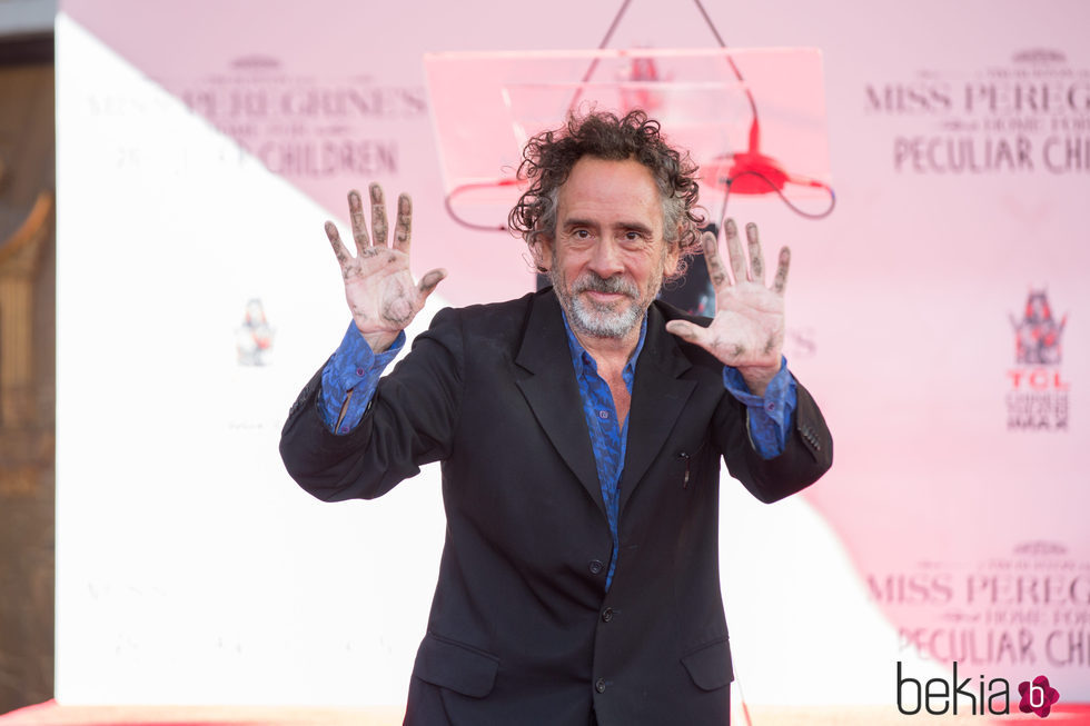 Tim Burton motrando sus manos tras dejar sus huellas frente al Teatro Chino de Hollywood